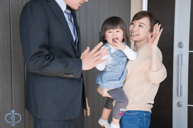 スーツ姿の男性を玄関で迎える女性と子どもの画像。出張と言っていた男性が実は家族の元へ通っていた事実を示すシーン。