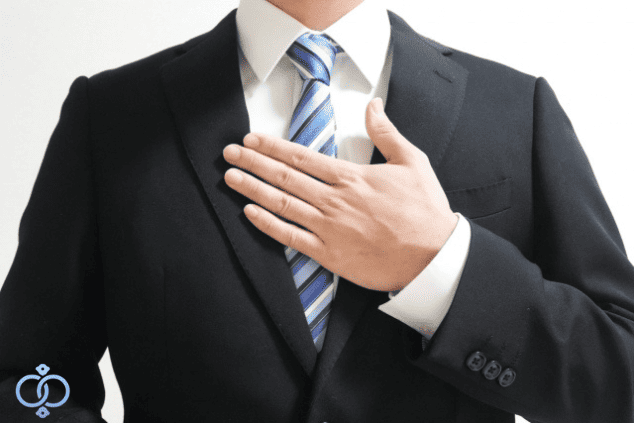 胸に手を当てたスーツの男性