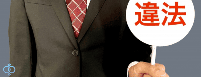 スーツを着た男性が違法と書かれた札を掲げている写真