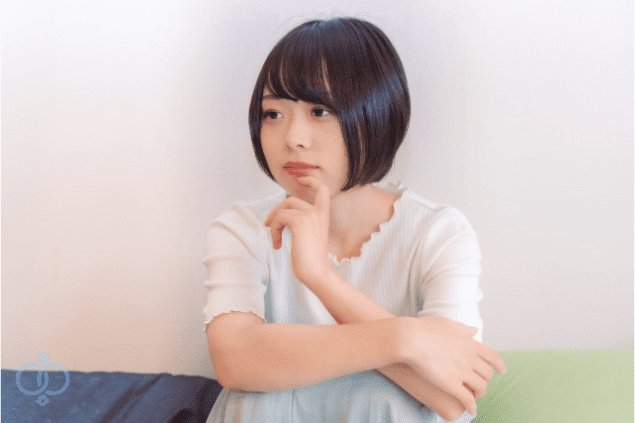 静かな表情で考え込む若い女性の画像。LINEから電話番号を調べようとする前に、自分でできる対応を冷静に見直している様子を表現。