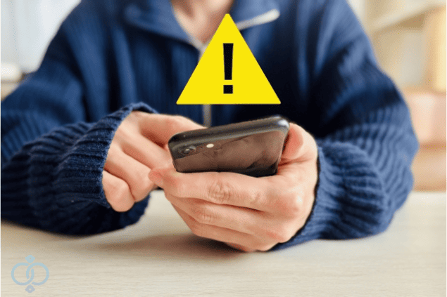スマートフォンを操作中に警告が表示されている様子を表現した画像。違法な電話番号の調べ方をしようとしていることへの注意喚起イメージ。