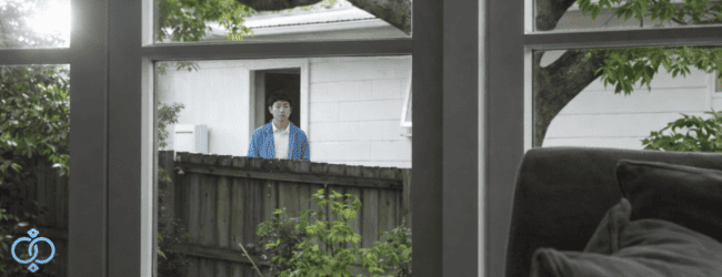 隣の家の庭からこちらを見つめる男性