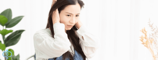 耳をふさぐ女性
近隣の生活音が原因でストレスを感じている様子をイメージ