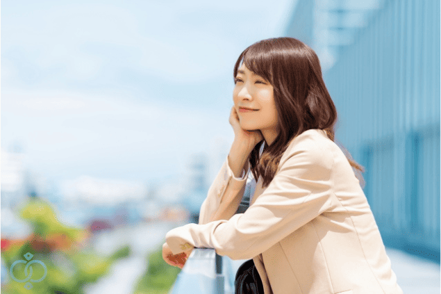 晴れた空の下で遠くを見つめる女性。感情に飲まれず、自分の未来を守る冷静な選択をしようとする姿を表現。