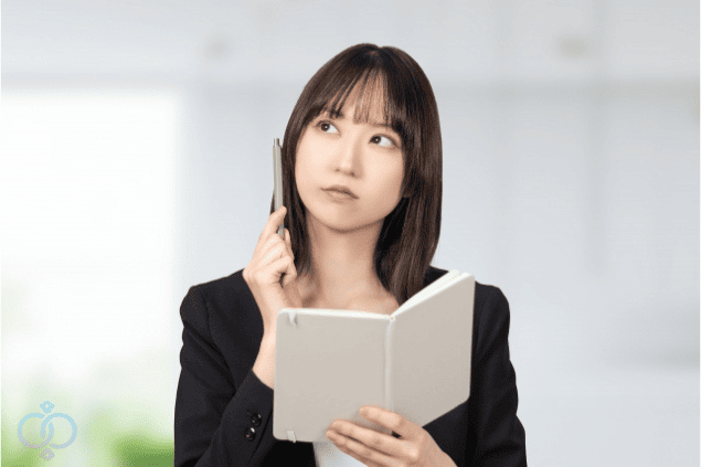 ノートを見ながら考え込む女性。彼が既婚者かもしれないと疑い、言動や状況を思い返して事実を整理しようとしている様子。