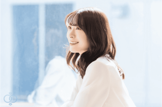 明るい表情で窓の外を見つめる女性の画像。事実と向き合った上で、自分の未来を前向きに考えている様子を表現している。