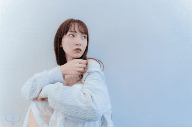 淡い表情で遠くを見つめる女性。リスクを避けるために、早めに本当のことを知ろうとしている様子。