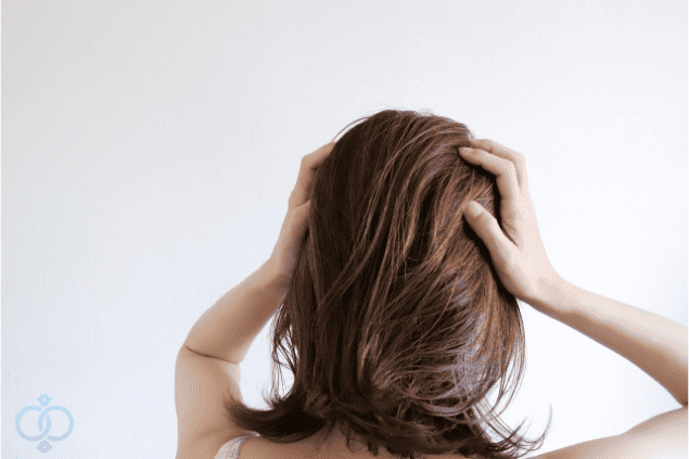 頭を抱えて動揺している女性の後ろ姿の画像。既婚者との交際によって思わぬリスクに気づいた女性の心情を表現している。