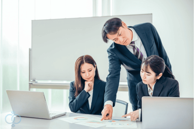 スーツ姿の探偵スタッフが資料を指しながら調査プランを説明している画像。風俗嬢の人探し調査で探偵がどのように情報を集めて進めるのかを表現。