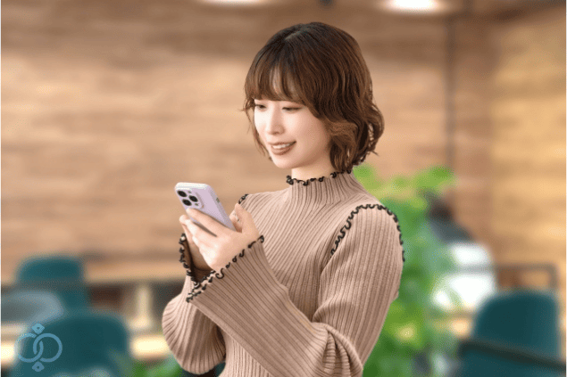 スマートフォンを見ながらほっとした表情を浮かべる女性の写真。探偵へのストーカー調査依頼に関する記事を読み終え、安心感と前向きな気持ちを得た読者のイメージを表現したまとめセクション画像。