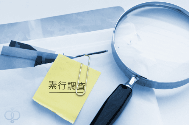 素行調査と書かれたメモと虫眼鏡、封筒のイメージ。探偵に相談した事例を示すイメージ画像。