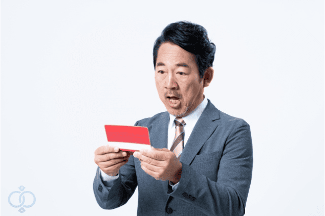 通帳を見て金銭被害に驚いている男性の画像。風俗嬢による結婚詐欺の実例と被害パターンを具体的にイメージさせる写真。