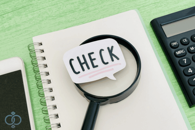 ノートの上に置かれた虫眼鏡と「CHECK」と書かれた吹き出しの画像。風俗嬢との交際で結婚詐欺に遭わないための対策と見極めポイントを表現。