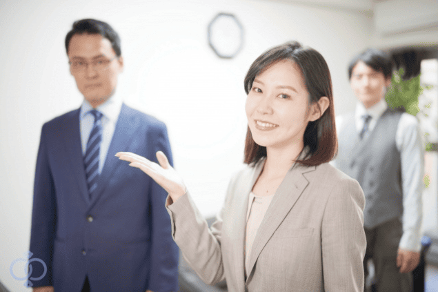 探偵事務所のスタッフが笑顔で相談を案内している様子の画像。風俗嬢による結婚詐欺に遭った場合でも諦めずに解決への道筋があることを表現。