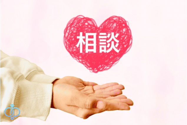 両手を差し出し、赤いハートに『相談』と書かれたイラスト。結婚に不安を感じている人のための24時間相談窓口を表すイメージ。