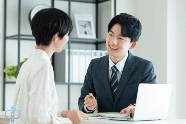 相談員が笑顔で女性の話を聞く写真。家族間の金銭トラブルに関する相談や解決支援をイメージした構図。