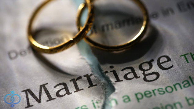 敗れた紙の上に置かれた結婚指輪