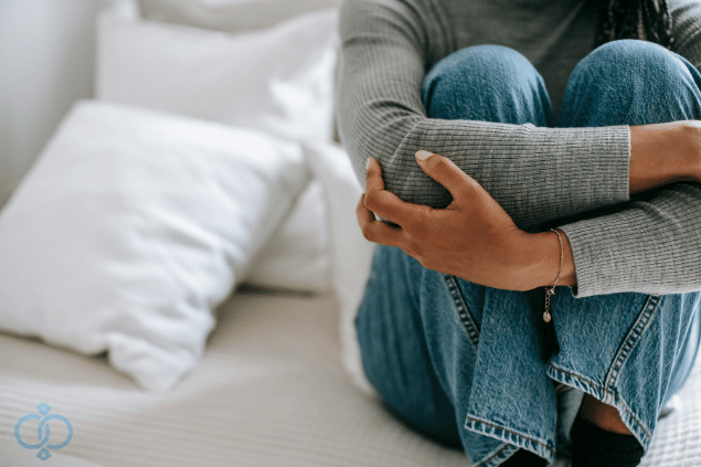 女性が膝を抱え悩んでいるイメージ画像
