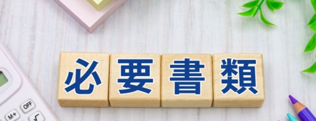 探偵に依頼する際に必要な書類をイメージした写真。「必要書類」と書かれたブロックと電卓、文房具が並んでいる。