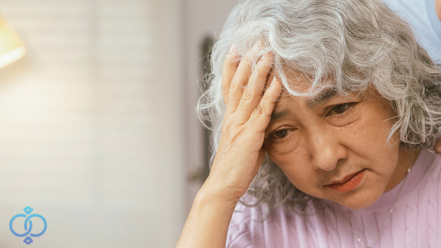 頭を抱えるシニア女性