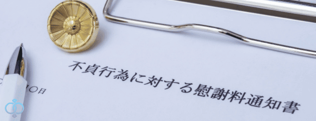 不貞行為に対する慰謝料通知書と書かれた書類と弁護士バッヂとボールペン