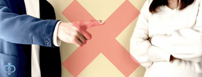 相手を指さして責める男性と腕を組む女性の間に大きな赤いバツ印の画像。