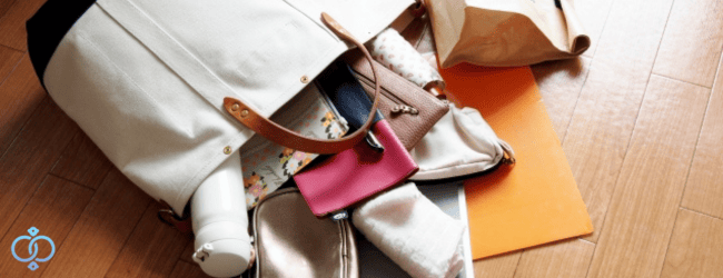 女性もののバッグから中身がこぼれ出ている画像。浮気の証拠をバッグから探している様子をイメージ