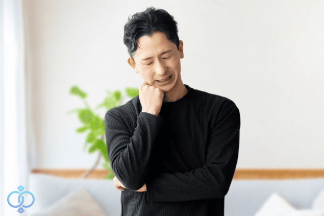 首を傾げ考え込む男性。浮気発覚後の対応に悩む様子をイメージした画像