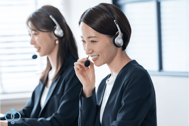 ヘッドセットを付けた女性が笑顔で相談応対している様子のイメージ画像