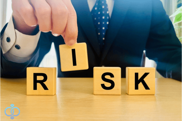 スーツ姿の男性がリスクと書かれたブロックを並べている様子