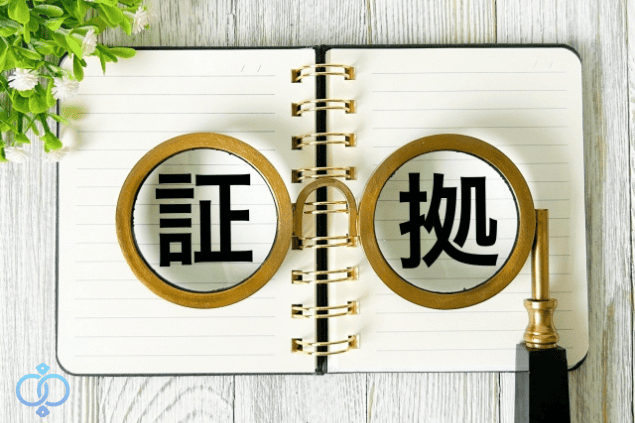 ノートの上に置かれたメガネの中に証拠の文字が強調されている画像