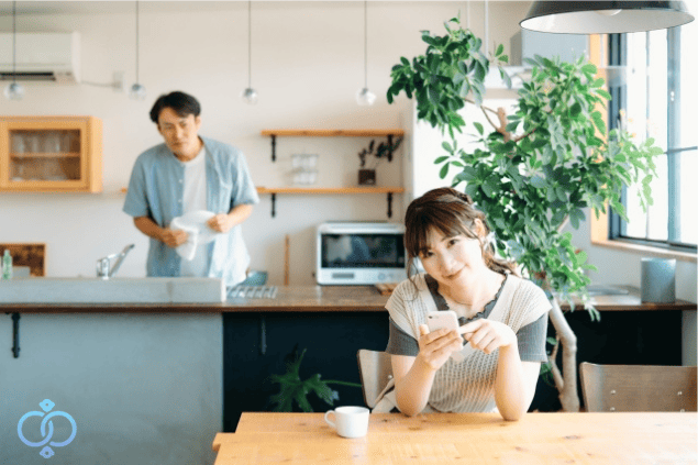 キッチンから妻を怪しげに見つめる夫