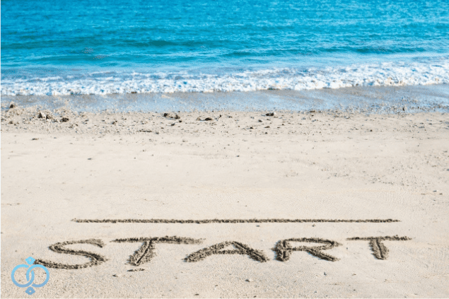 海辺の砂浜にSTARTと書かれた風景写真。読者の再スタートをイメージした写真