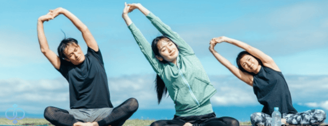 男女3名が屋外でストレッチをしている様子。