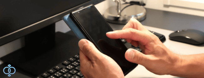 スマートフォンを手に家族や友人に連絡するか、悩む様子を表現した画像