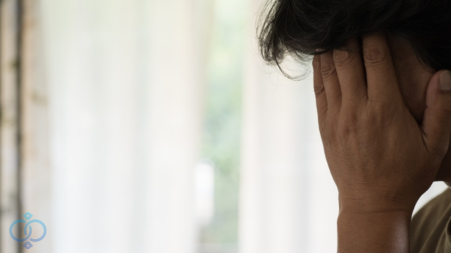 手で顔を覆う老人