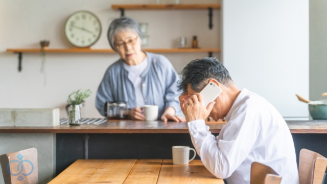 心配そうな様子で電話をかける老夫婦