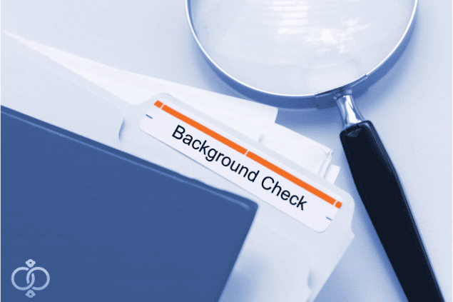 虫眼鏡とBackgroundcheckと書かれた書類の写真。探偵の身辺調査イメージ画像