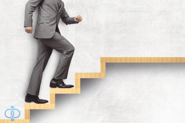 階段を上がるスーツの男性。前に進む様子を表現。