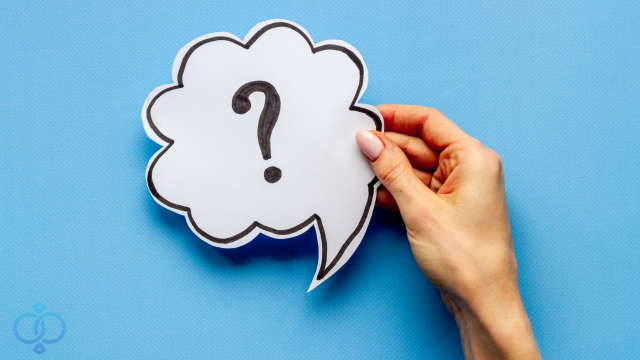 はてなマークを持つ女性の手