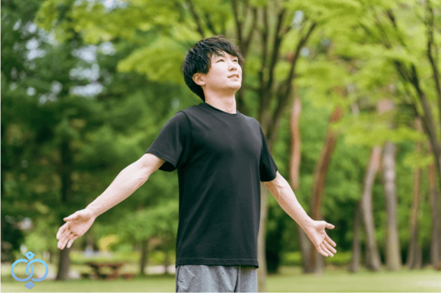 屋外で深呼吸をして、4.7.8呼吸法を実践する男性の様子をイメージした画像