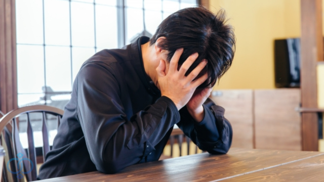 頭を抱えて悩む男性