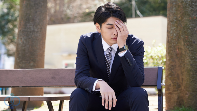 ベンチで頭抱える男性