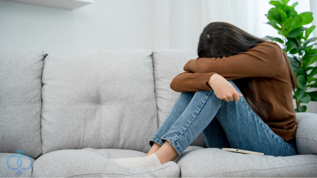落ち込みソファーにうずくまる女性