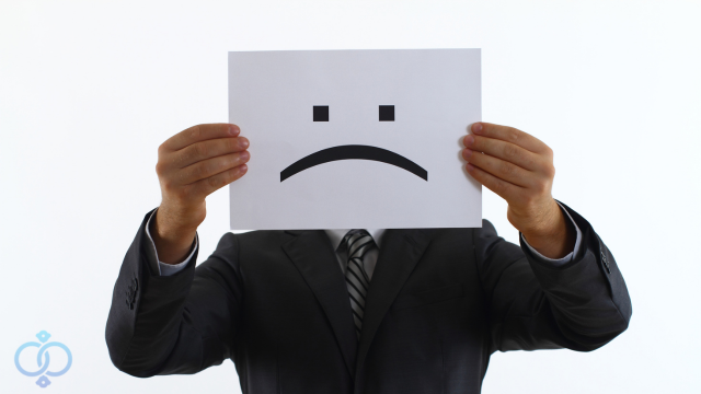 不安な表情が書かれた紙を持つ男性