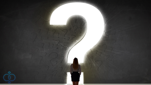 はてなマークの前に立つ女性