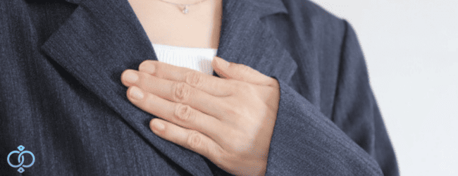 胸に手を当てた女性。トラウマの症状を理解しようとするイメージ画像