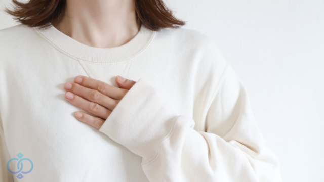 胸に手を当てて考える女性