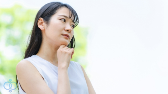 不安を拭えず考えている女性