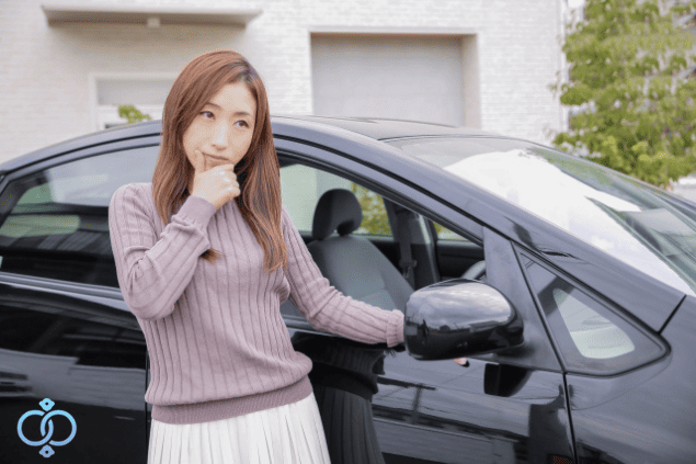 車にGPSが取り付けられる理由について、車のそばで不安そうに考える女性のイメージ